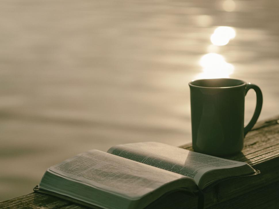 a book and a mug on a wood surface